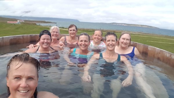 A group of women in a hot tub on all womens tour and solo female travel in Iceland